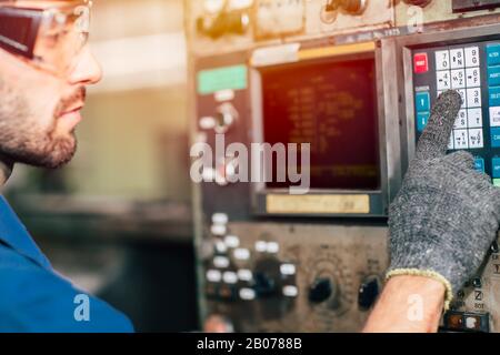 closeup factory worker man operate the machine, high skill labor work industry with safety clothes. Stock Photo