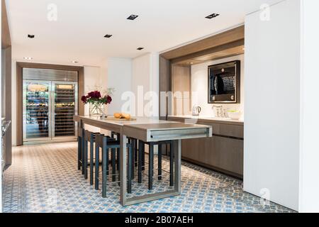 Modern kitchen with table and stools Stock Photo