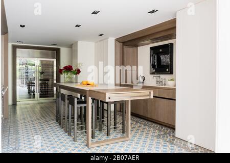 Modern kitchen with table and stools Stock Photo