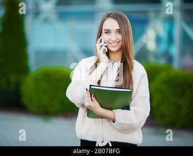 Businesswoman talking on mobile phone in Lviv cityscape background Stock Photo