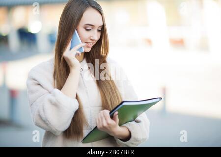 Businesswoman talking on mobile phone in Lviv cityscape background Stock Photo