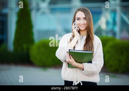 Businesswoman talking on mobile phone in Lviv cityscape background Stock Photo