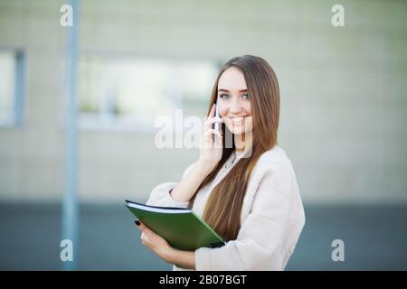 Businesswoman talking on mobile phone in Lviv cityscape background Stock Photo