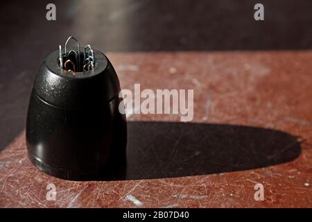 paper clip sticking out of a magnetic jar Stock Photo