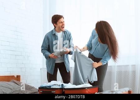 Packing suitcase. Loving couple preparing for trip Stock Photo