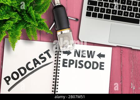 podcasting concept, top view of podcast recording equipment and notepad with text new episode on pink wooden table Stock Photo