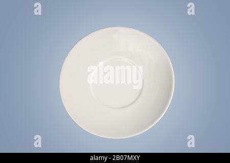 white empty saucer isolated  on light blue background with empty space for text. Minimalism concept Stock Photo