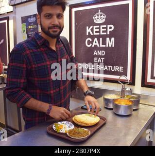 A boy eating chole bhature at Delhi best street food spot Stock Photo