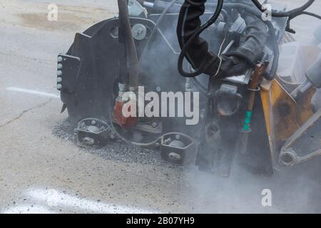 Road repair, milling machine cuts the close up of an old mounted road mill Stock Photo