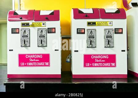 Simple colorful pay cellphone charging stations standing on a table inside a tourist travel area, used by travelers, seen in the Philippines, Asia Stock Photo