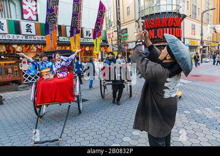 Japan, Honshu, Tokyo, Asakusa, Asakusa Street Scene showing Tourists Dressed in Kimono Riding in Rickshaws Stock Photo