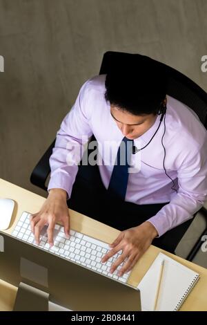 Late Night Environment. Top view of friendly operator call center with headsets working hard at night. Using for 24 Hr. 7 days Call centre Concept. Stock Photo