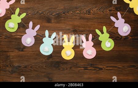 Eater background. garland of paper rabbits on a wooden background. bunny background. Spring decor. copy space Stock Photo