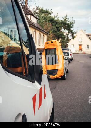 Construction van with broken rear view mirror glued with orange worker scotch band Stock Photo