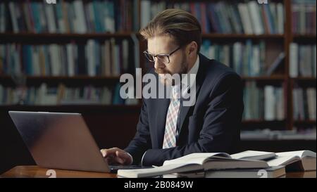Businessman working laptop in library Stock Photo