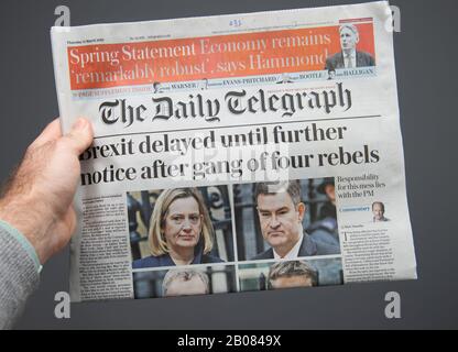 Paris, France - Mar 15, 2019: Male hand POV at the latest THe Daily Telegraph edition of newspaper featuring breaking news about delayed brexit Stock Photo