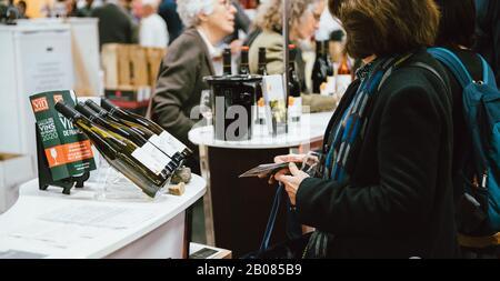 Strasbourg, France - Feb 16, 2020: Woman lloking at the Vignerons independant English: Independent winemakers of France wine fair for private and horeca customers Stock Photo