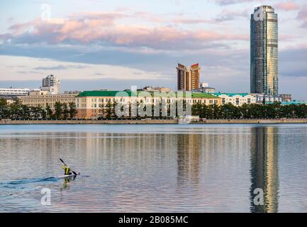 Reflection of Vysotsky Tower at sunset, Gorodskoy Prud or City Pond with kayaker paddling kayak, Yekaterinburg, Siberia, Russian federation Stock Photo
