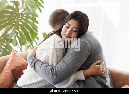 Loving Spouses Hugging After Couple Therapy Sitting In Psychologist's Office Stock Photo