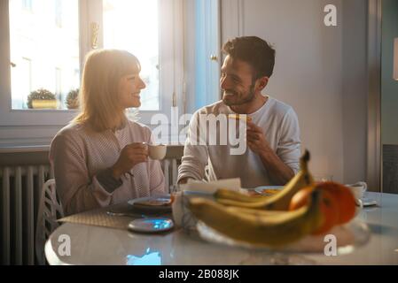 Happy couple making breakfast at home. Concept about lifestyle, healthy food and relationship Stock Photo