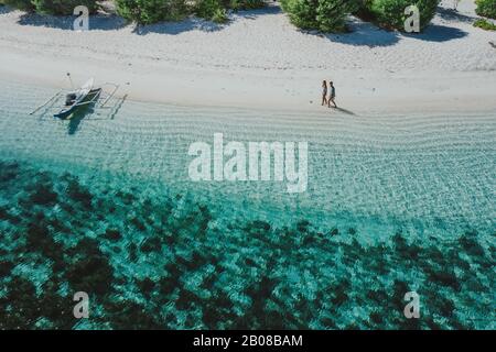 Couple spending time on a beutiful remote tropical island in the philippines. Concept about vacation and lifestyle. Aerial shot with the drone Stock Photo