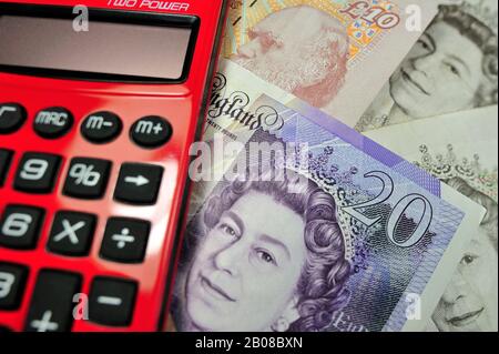 English banknotes in pound sterling and red pocket calculator Stock Photo