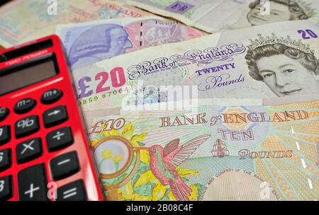 English banknotes in pound sterling and red pocket calculator Stock Photo