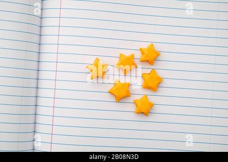 Yellow origami lucky stars on a lined paper. Close up. Stock Photo