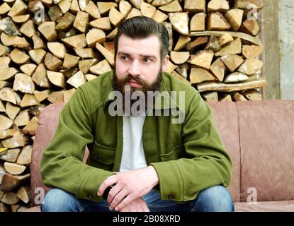 Men have a break on a patio in front of firewood Stock Photo