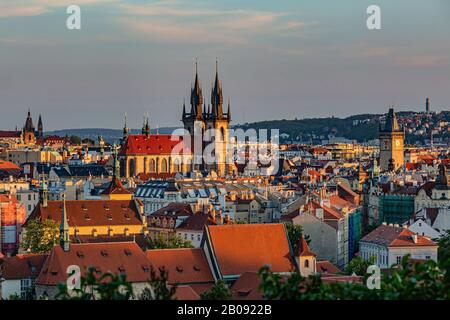 Prague / Czech Republic - May 23 2019: Scenic view of the cityscape, the Tyn Cathedral and Old Town Hall Tower on a spring sunny evening. Blue sky. Stock Photo