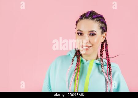 Young smiling fashionable woman with braids kanekalon. Colored artificial strands of hair. Stock Photo