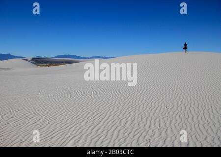 Person walking on white sand dunes, White Sands National Monument, New Mexico Stock Photo