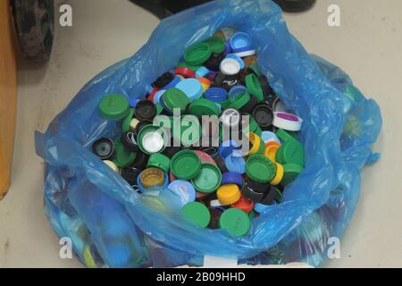 21.12.2019, Russia, Syktyvkar, collection of plastic caps from drinking bottles for recycling. Environmental protection concept, informed consumption. Stock photo with empty space for text. Stock Photo