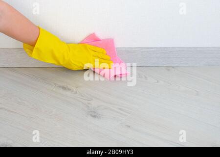 Cleaning floor in room close up. Woman cleaning parquet floor with rag at home. Housework and housekeeping concept. Stock Photo