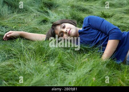 Girl lying in green grass Stock Photo - Alamy