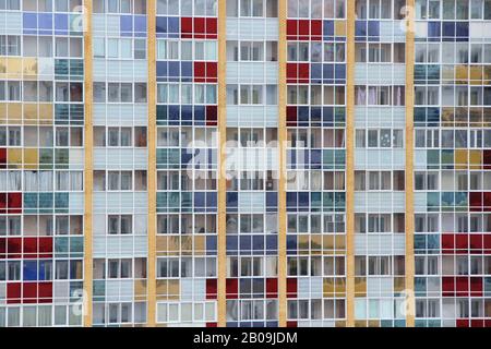 Wall of a modern brick tiled house with rows of windows and multi-colored stained glass. Stock photo for web, print, background and wallpaper, with empty space for text  Stock Photo
