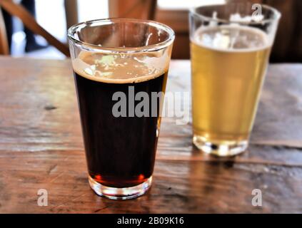 two pints of beer on table one dark and one light beer Stock Photo