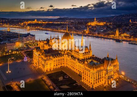 Budapest, Hungary - Aerial view of the beautiful illuminated Parliament of Hungary at dusk with Szechenyi Chain Bridge, Fisherman's Bastion and other Stock Photo