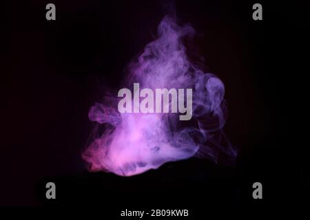 Abstract neon light smoke effect on black background. Smoke cloud explosion. Stock Photo