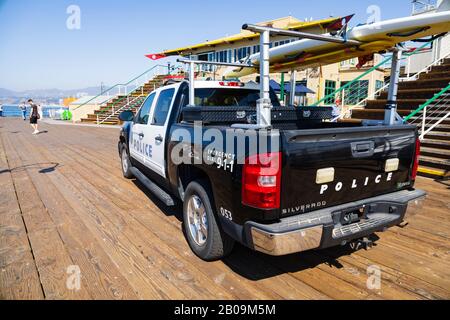 Chevrolet Silverado Hybrid police patrol pickup with surfboard, on the end of Santa Monica pier. California, United States of America Stock Photo