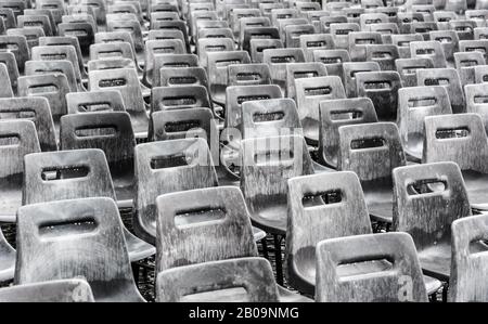 Rows of empty gray chairs in the rain, background. Stock Photo