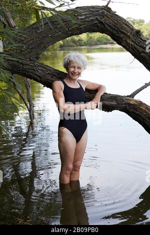 beautiful 65 year old woman swimming in lake Stock Photo