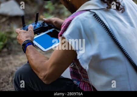 A close up selective focus shot of a young muscular man using a radio controlled drone remote with tablet device digital screen. Copy space to right Stock Photo