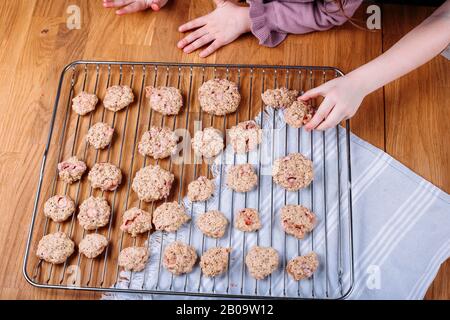 Strawberry Chocolate Chip Cookies. Kids hands taking homemade buscuit Stock Photo