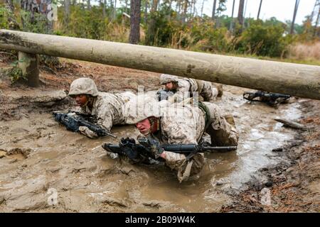 U.S. Marine Corps recruits with Delta Company, 1st Recruit Training Battalion maneuver through mud and barbed wire during the Combat Endurance Course December 21, 2019 at Marine Corps Recruit Depot Parris Island, South Carolina. Stock Photo