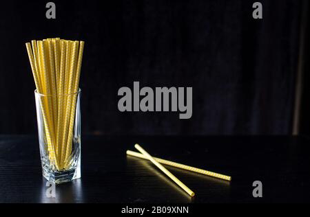 Lots of yellow tubes in a glass on a black background. Drinks Stock Photo