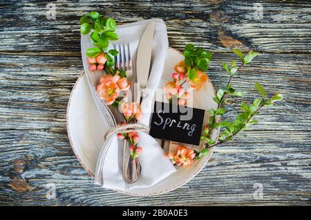 Festive table place setting with spring blossoming branch on wooden background. Copy space Stock Photo