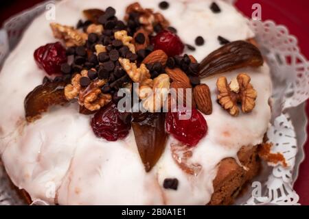 Sweet panettone with sugar, chocolate and dried fruits on the top Stock Photo