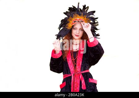 Girl dressed up in Carnival costume with feather mask and red beads. Stock Photo