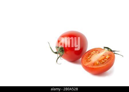 Whole fresh red cherry tomato with leaves, half fetus with small shadow isolated on white background. Macro, flat lay. Horizontal, close-up. Healthy e Stock Photo
